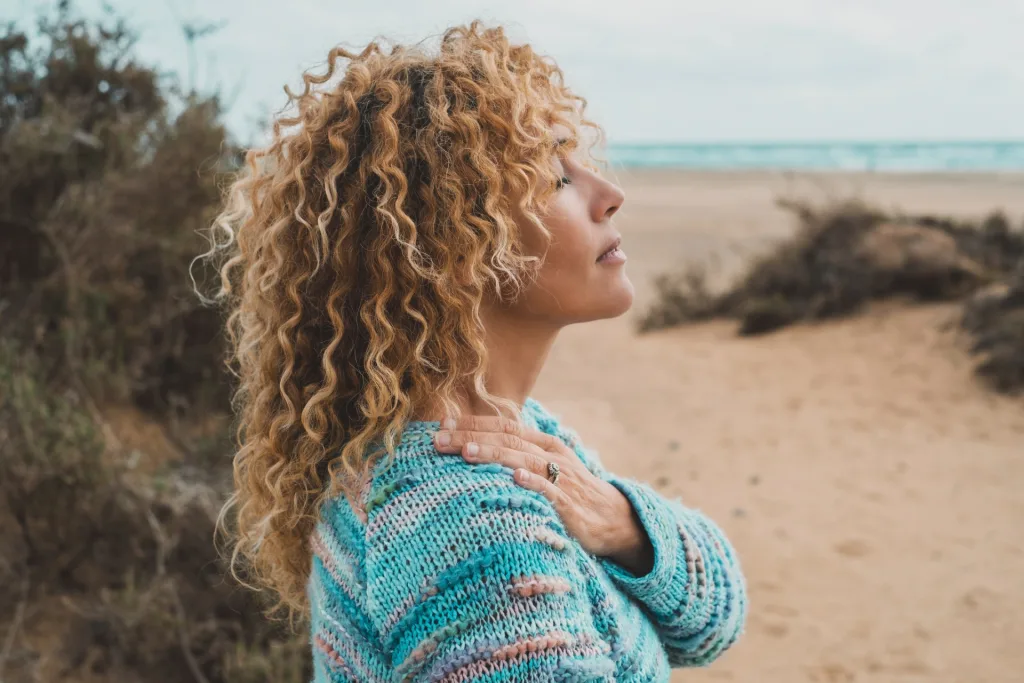 why you should meditate woman doing breathwork on sandy beach